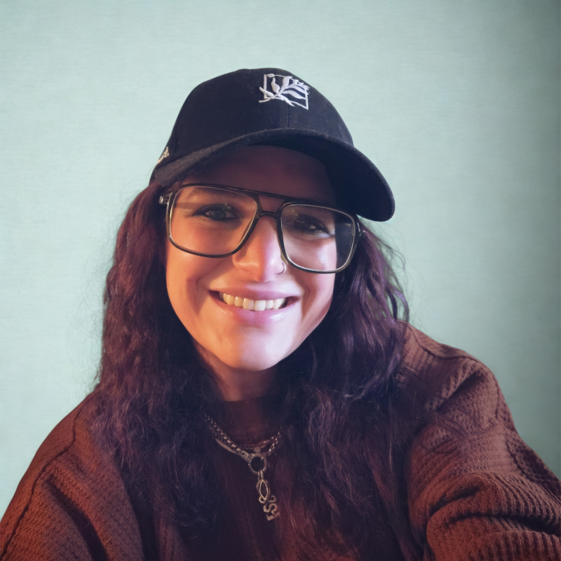 Morgan Avenia smiling in glasses and a baseball cap
